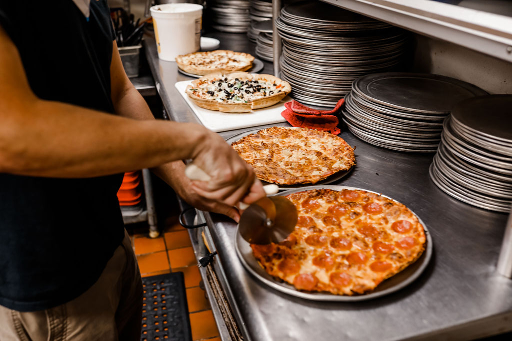 pizza being cut in slices