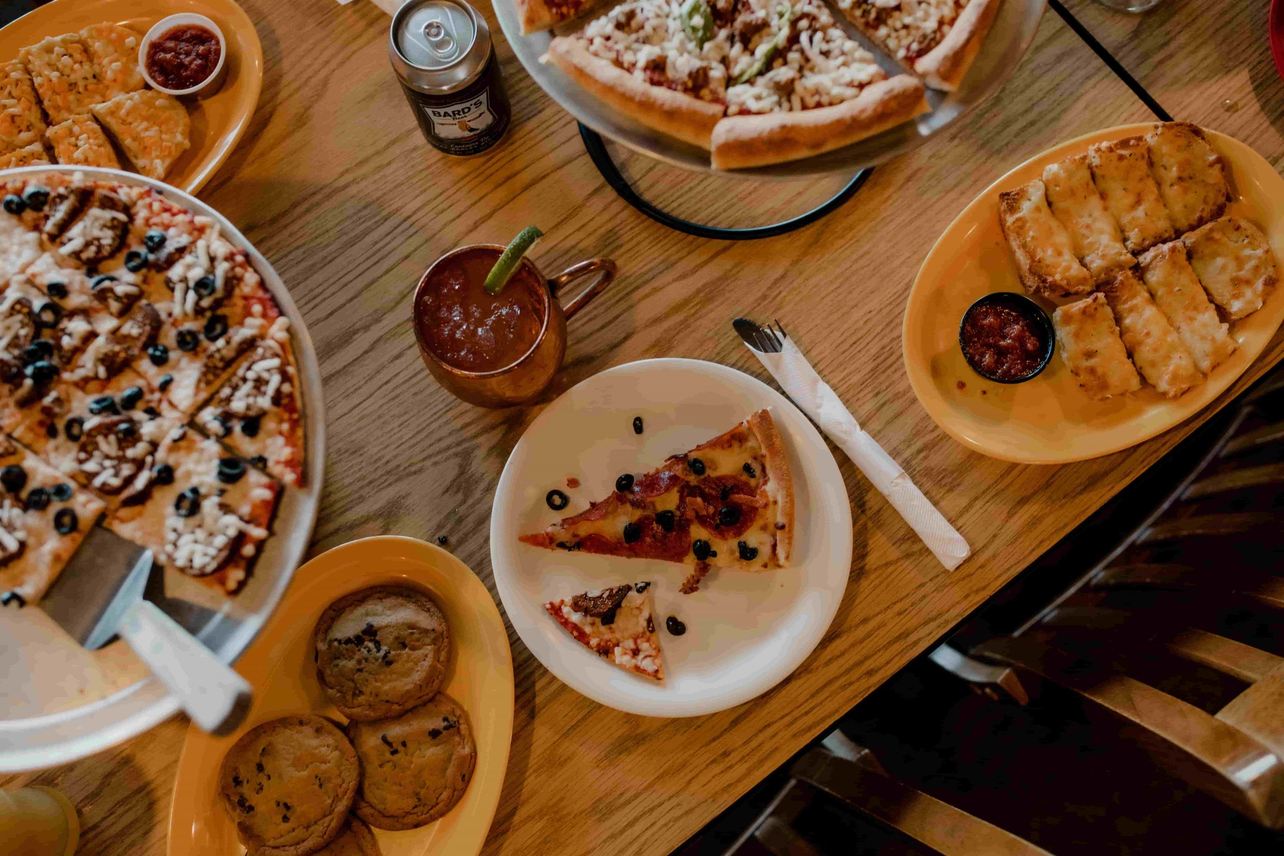 table of pizza and desserts